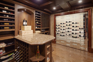 Wooden wine cellar with a glass windowed wall. In front of the window are several columns of floor to ceiling glass and cable Float wine racks.