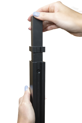 Two hands holding a piece of the V Bar floating wine rack against a white background.