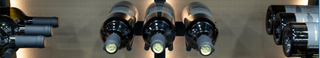 A close and wide shot of three sets of wine bottles on V Bar displays