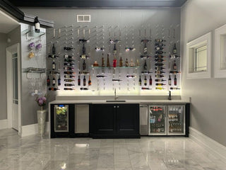Wall mounted wine pegs and single bottle wine perches above a countertop and sink